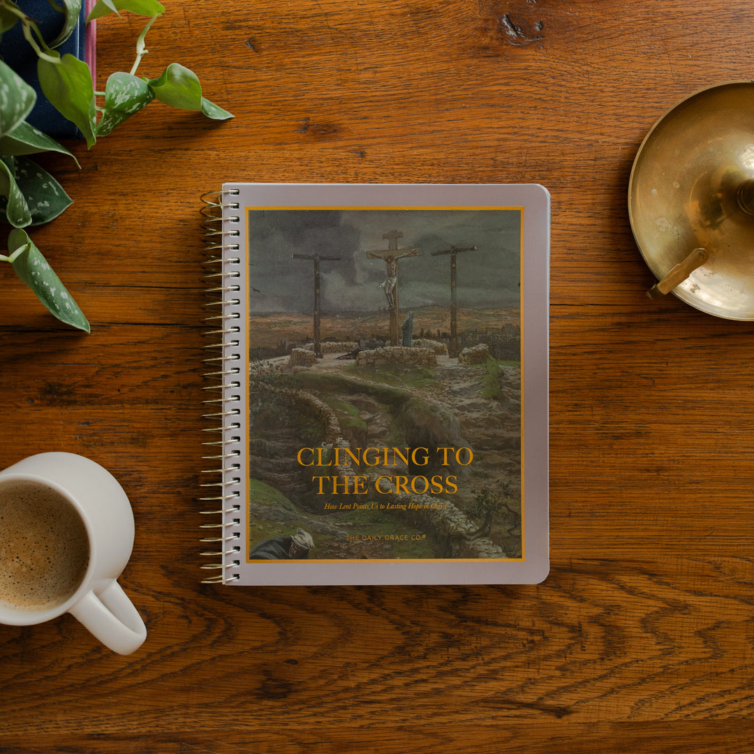 Clinging to the Cross Spiral study cover on a wooden table near a coffee cup and a bronze candle lamp