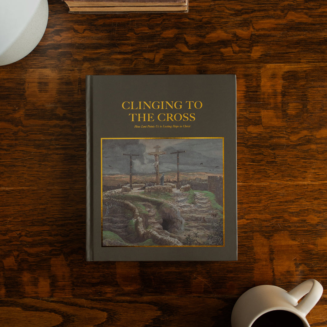 Clinging to the Cross Spiral hardcover cover on a wooden table next to a coffee cup