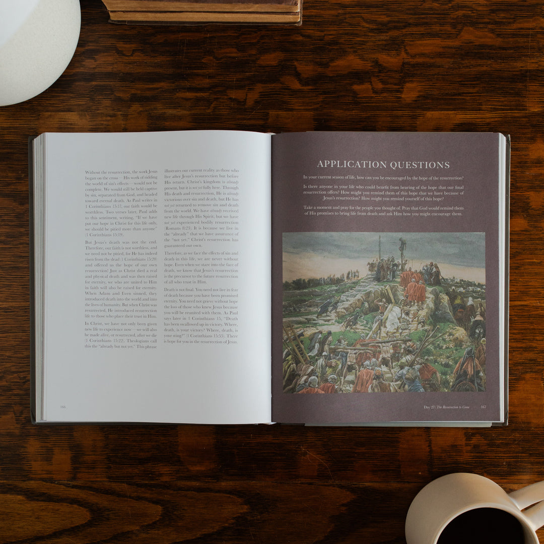 Clinging to the Cross Spiral hardcover opened to the applications and questions page on a wooden table next to a coffee cup