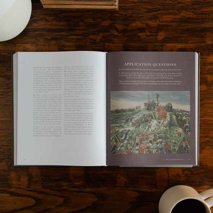 Clinging to the Cross Spiral hardcover opened to the applications and questions page on a wooden table next to a coffee cup