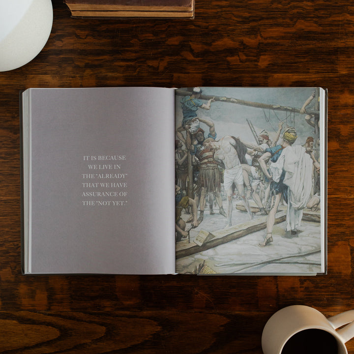 Clinging to the Cross Spiral hardcover opened to the devotional page on a wooden table next to a coffee cup