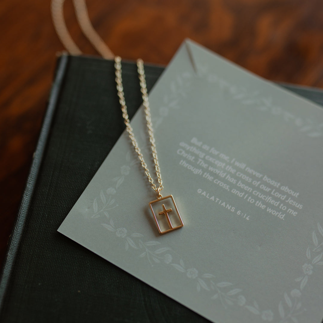 Cut out cross necklace on a verse card on a journal