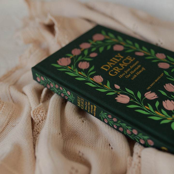 Up close of The Daily Grace Hardcover book cover and spine on some white blankets