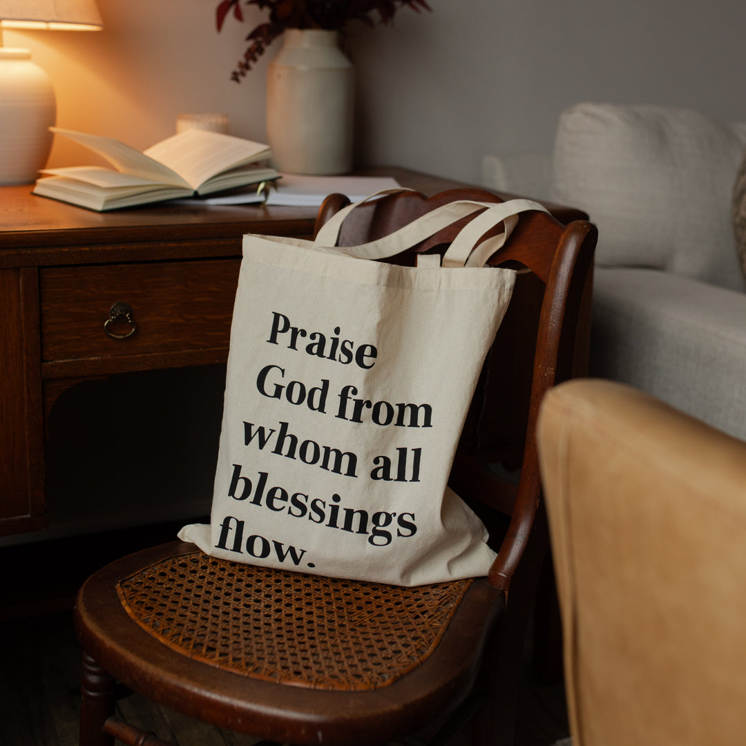 Tote bag with inspirational quote on a chair in a cozy living room setting