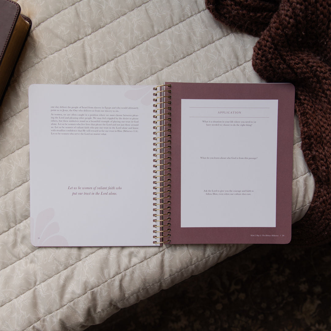 Open spiral-bound bible study on a textured surface with a brown cover