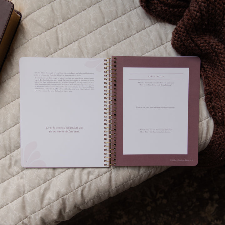 Open spiral-bound bible study on a textured surface with a brown cover