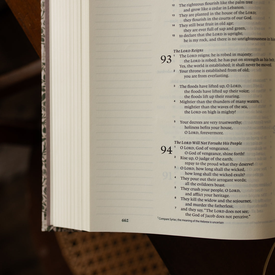 The Clover Journaling Bible opened with text and page numbers on a wooden surface