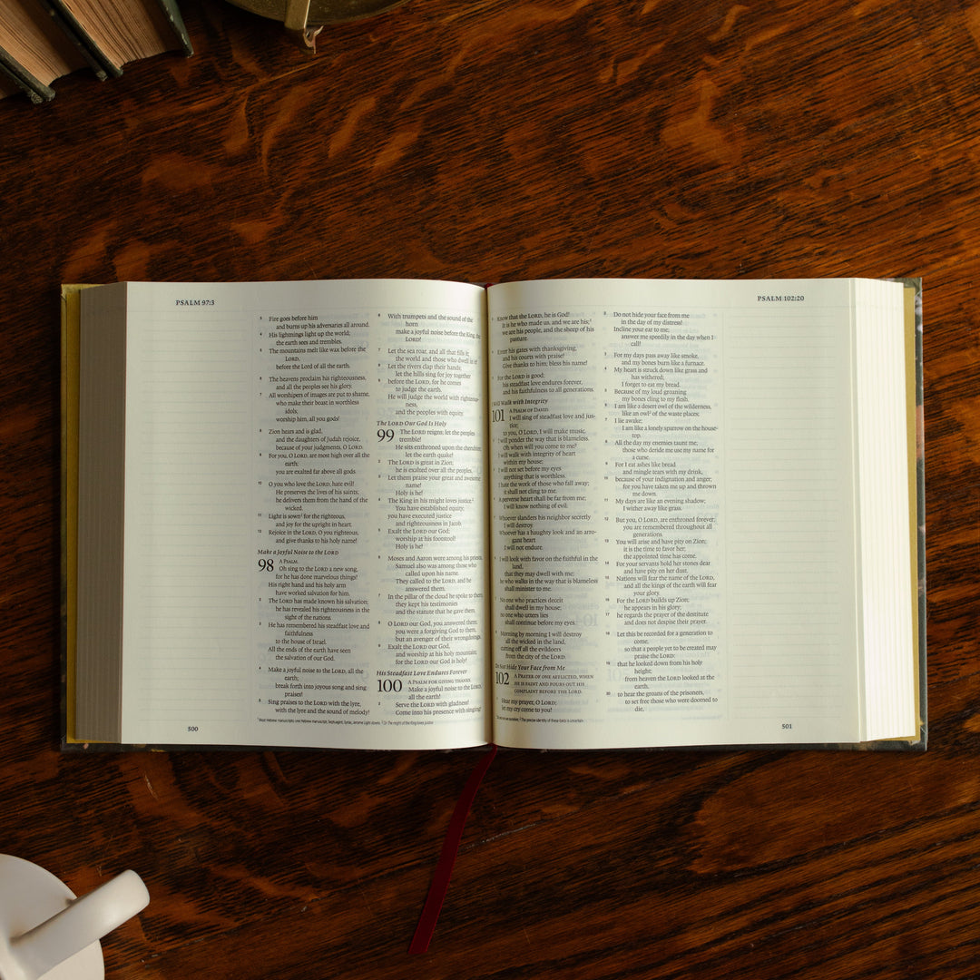 ESV journaling Fields Bible opened to Psalms on a wooden table next to a white coffee cup
