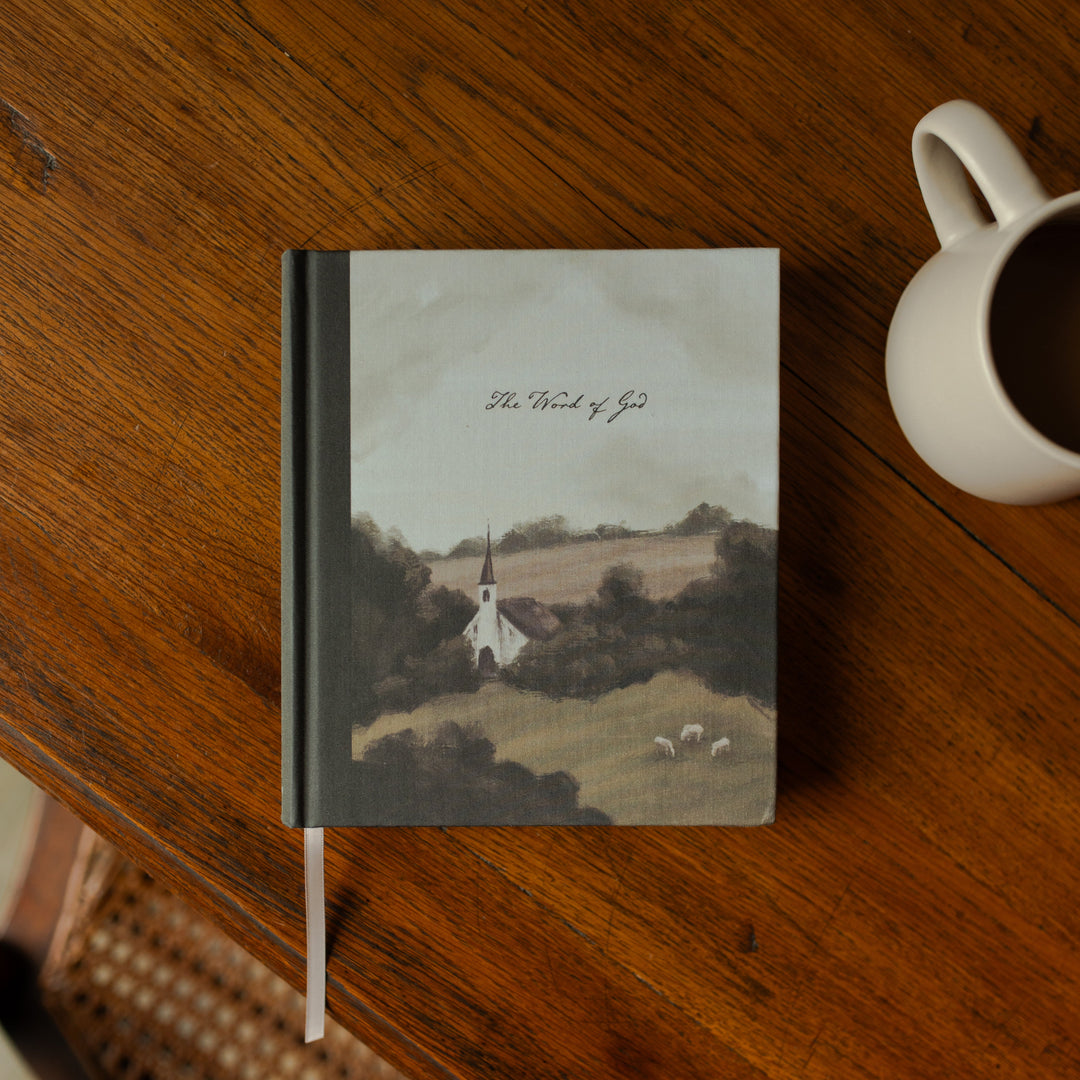 ESV Journaling Good Shepherd Bible cover on a wooden table next to a white coffee cup
