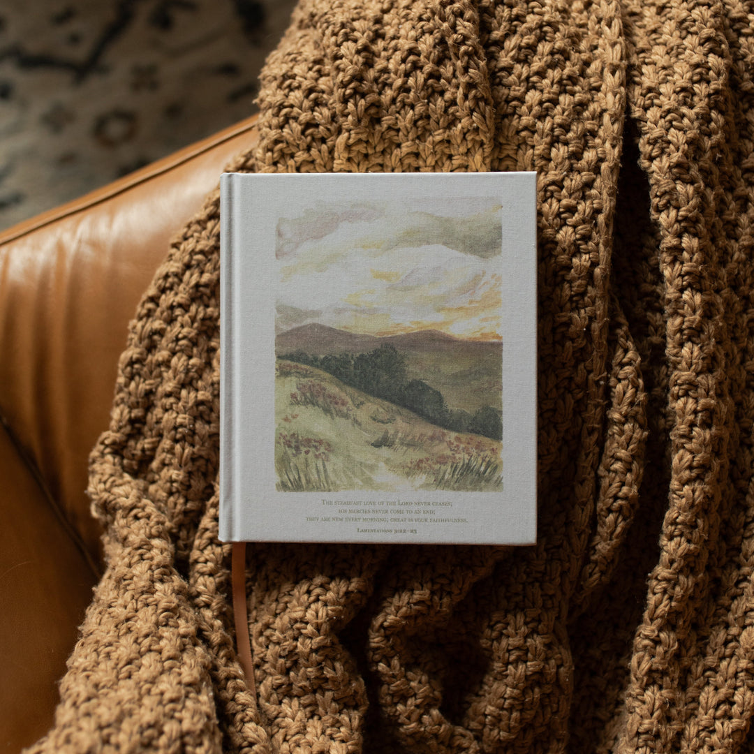 ESV Journaling New Mercies Bible cover on a brown woven blanket and a leather couch