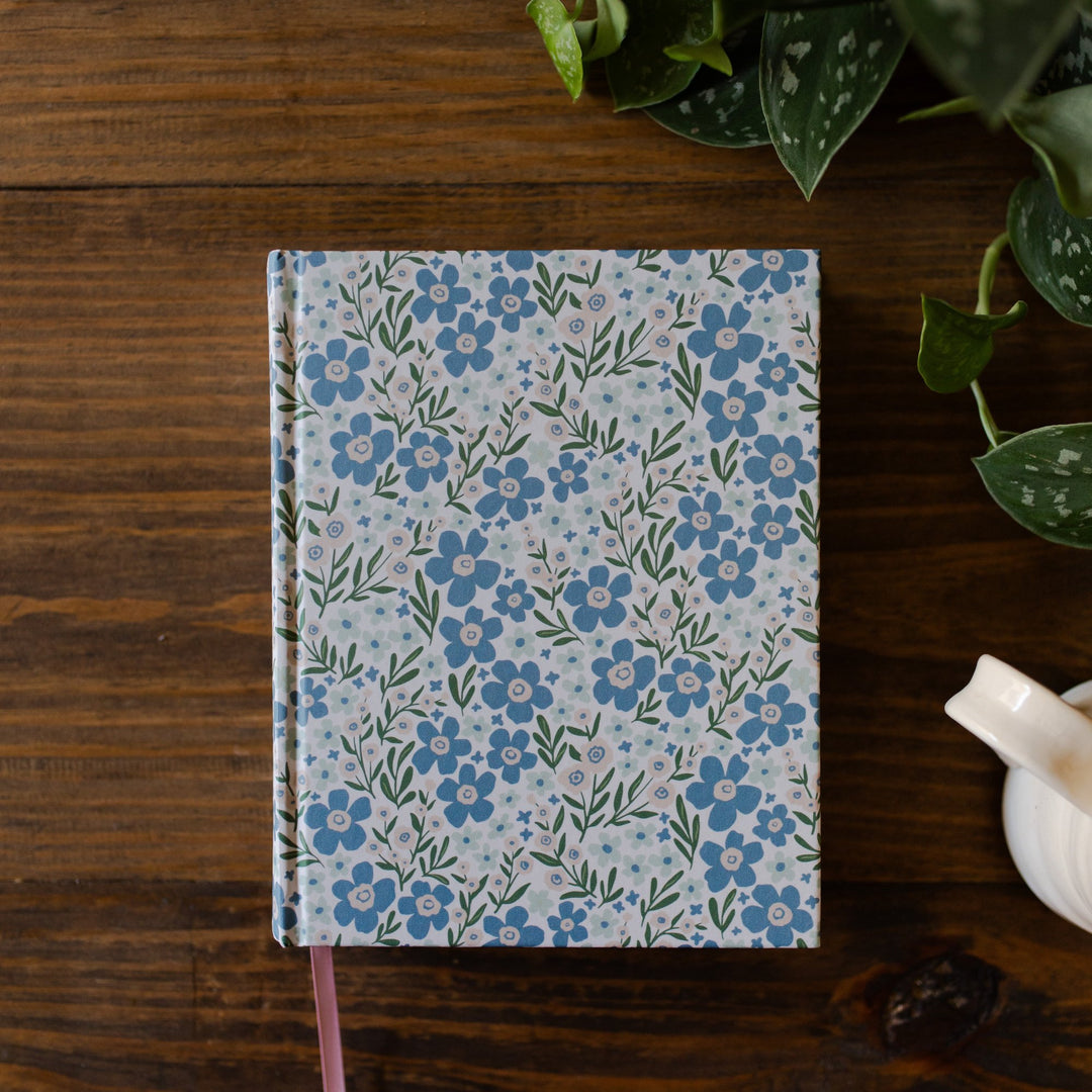 Blue flower ESV bible sitting on wood table