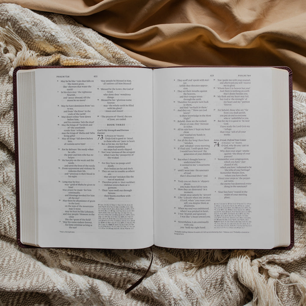 an open leather bible opened to Psalms 73 on a textured blanket