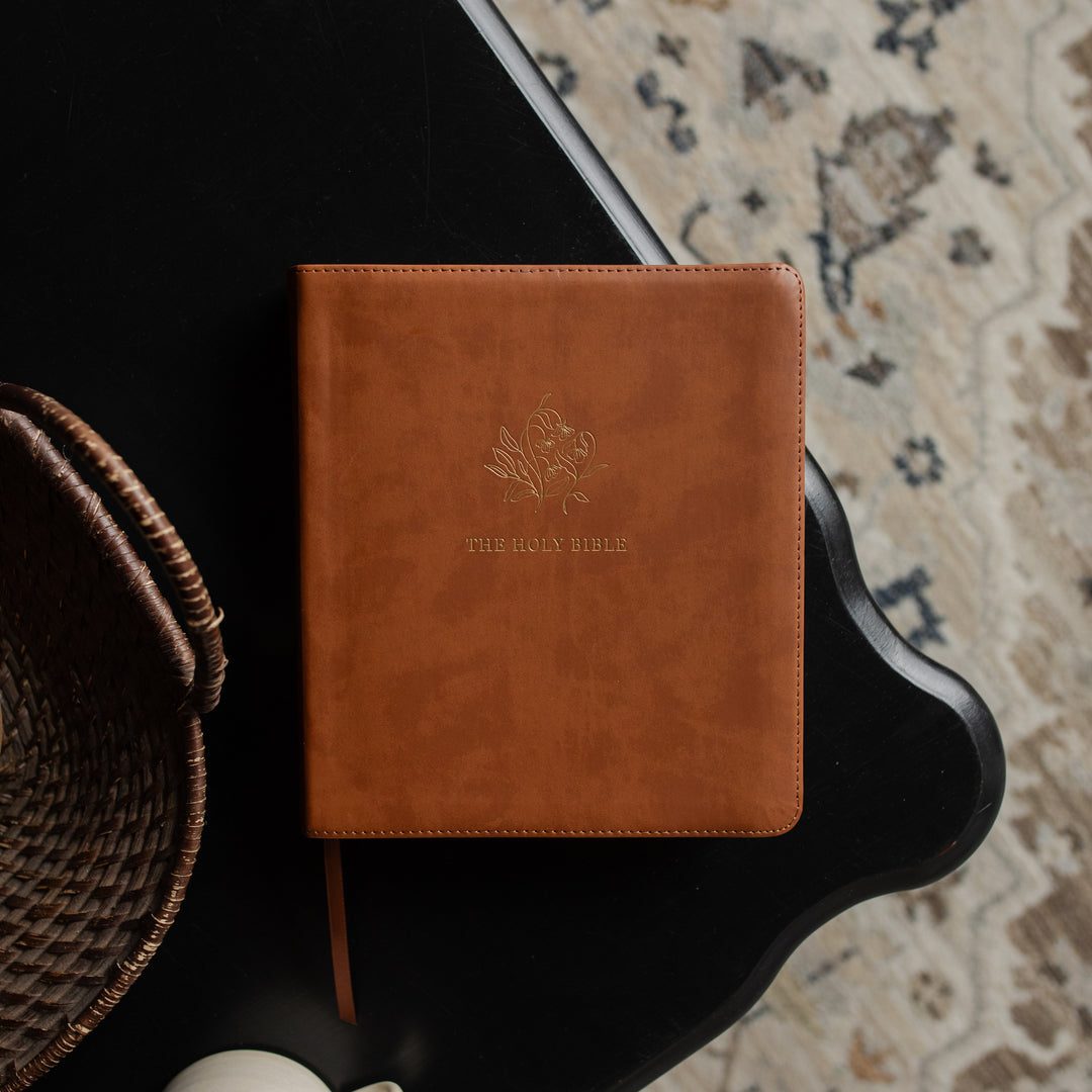A leather ESV bible cover on a dark wooden table
