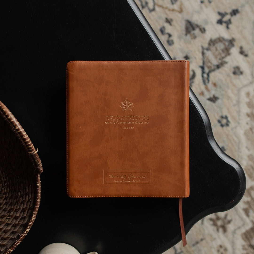 The back of a leather ESV bible cover on a dark wooden table