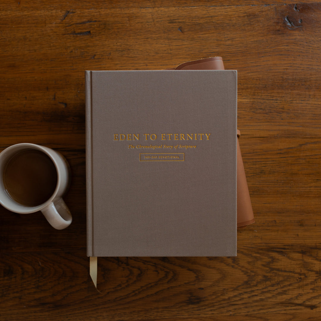 Eden to Eternity Devo cover on a leather wrapped bible next to a coffee cup on a wooden table
