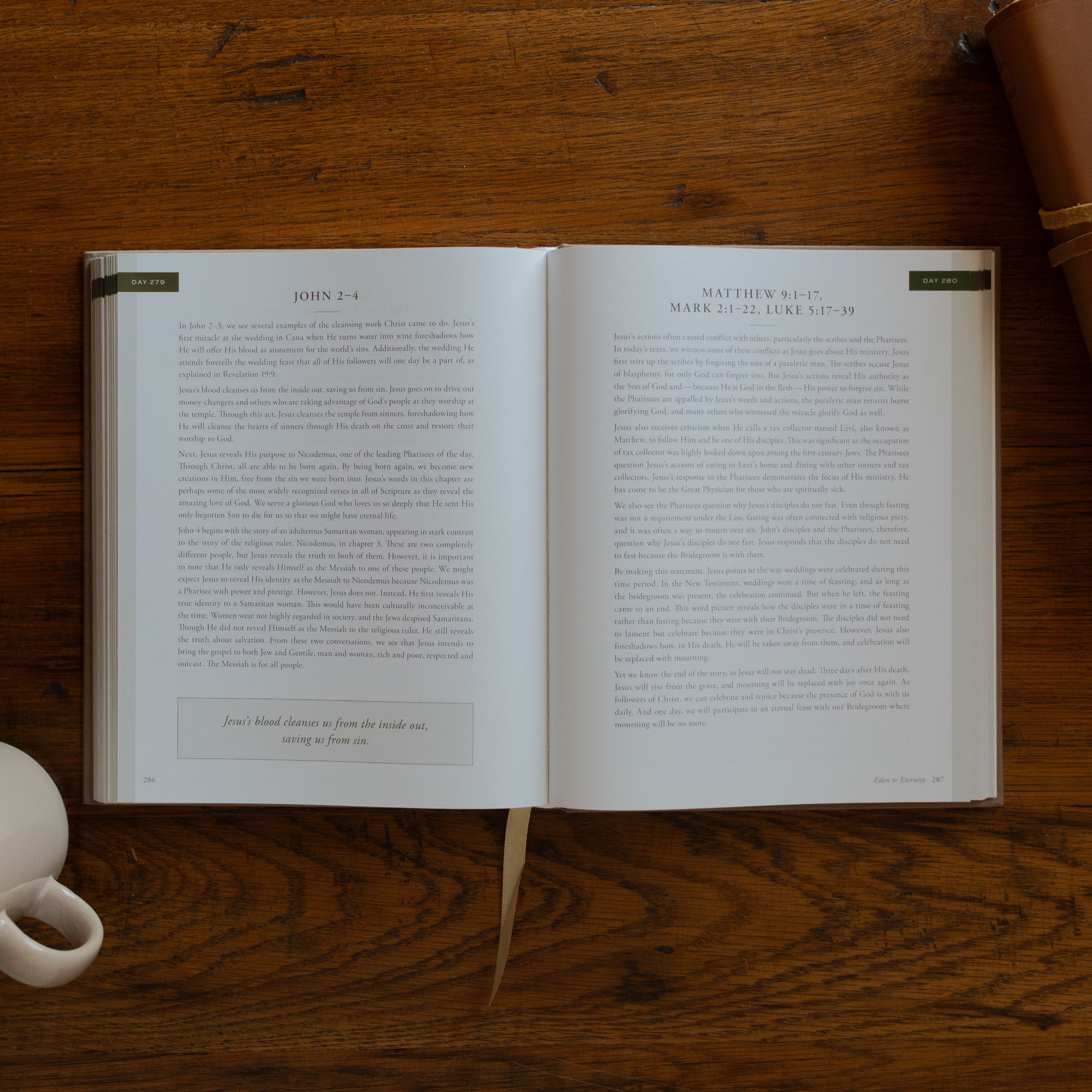 Eden to Eternity Devo opened to day 279 page next to a coffee cup and a leather bible on a wooden table