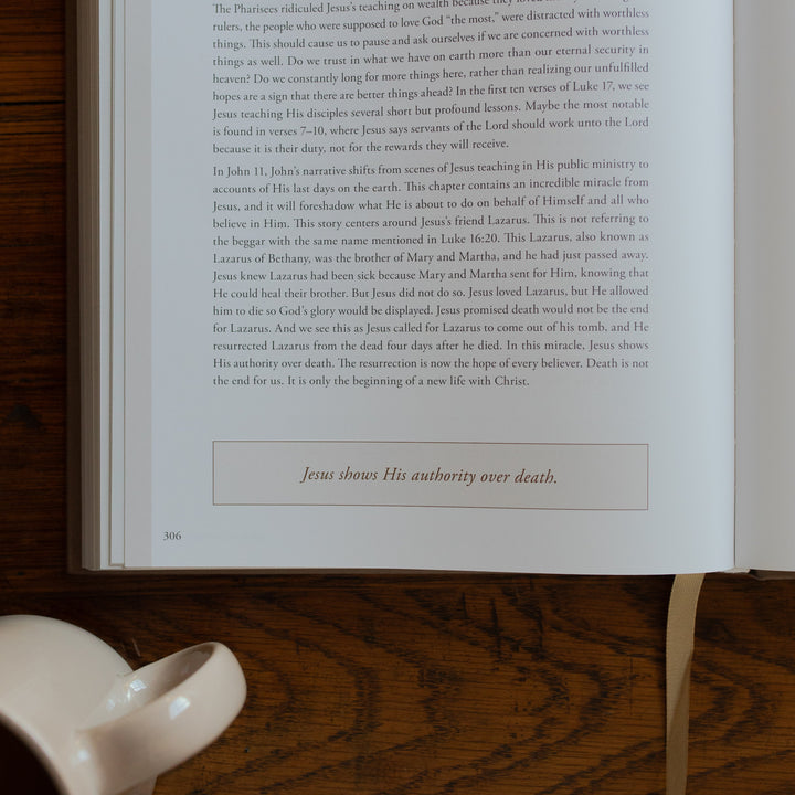 Up close of the Eden to Eternity Devo opened to page 306 next to a coffee cup on a wooden table