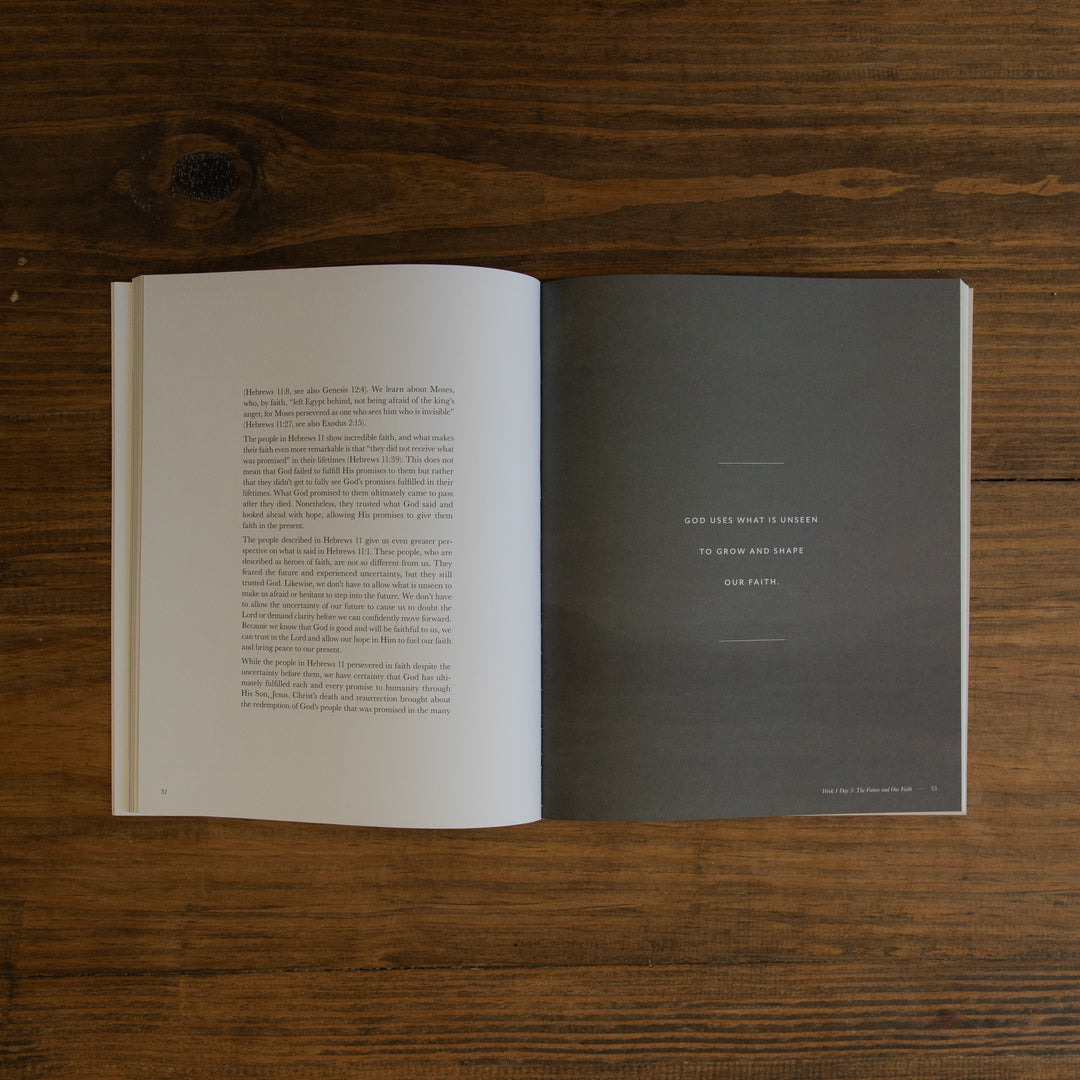 An open book showing a green page on the right spread on a dark wood tabletop.