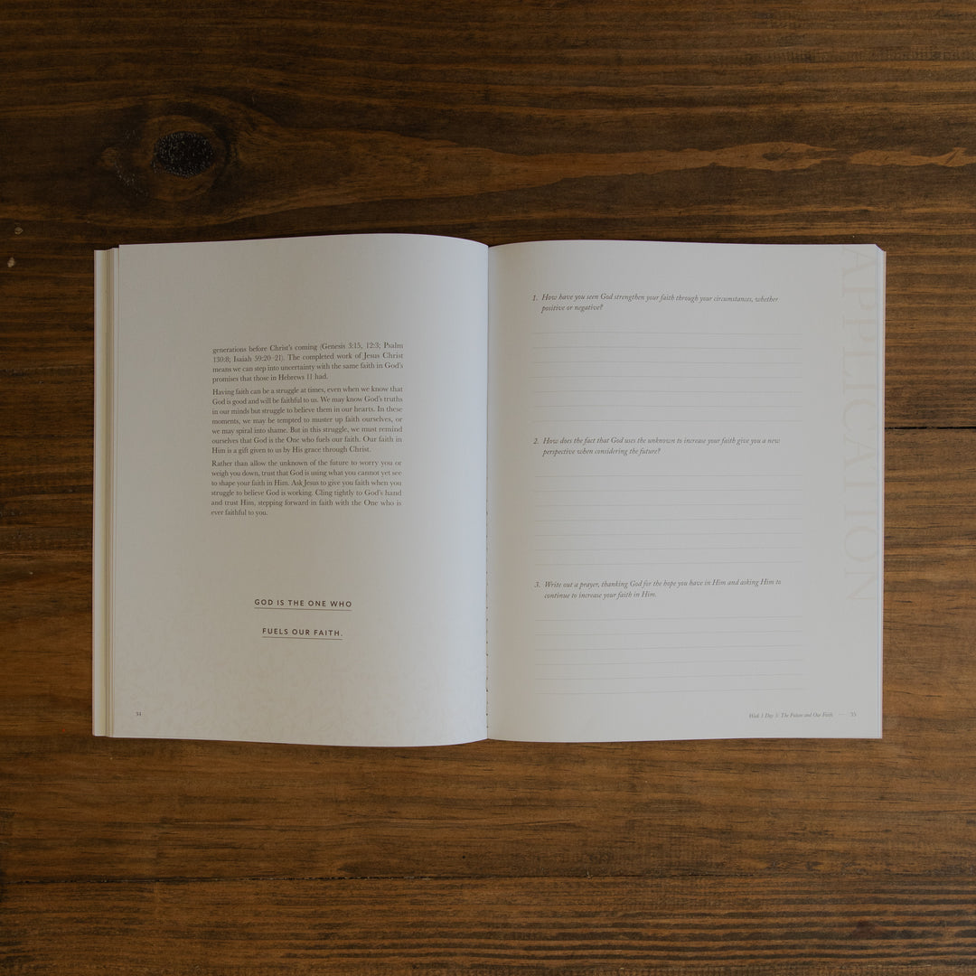 An open book with printed text on the left page and lined writing space on the right page, placed flat on a dark brown wooden surface.