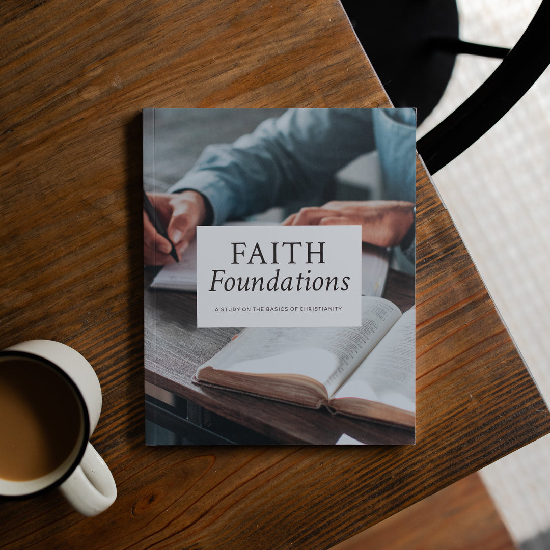 Faith Foundations Mens study cover on a brown wooden table next to a white coffee cup