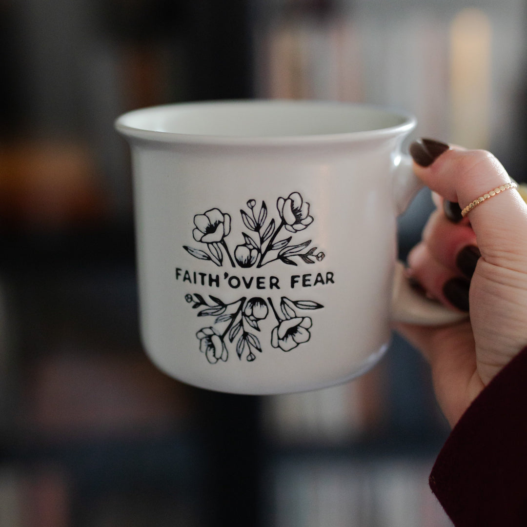 white campfire mug with the words faith over fear and florals