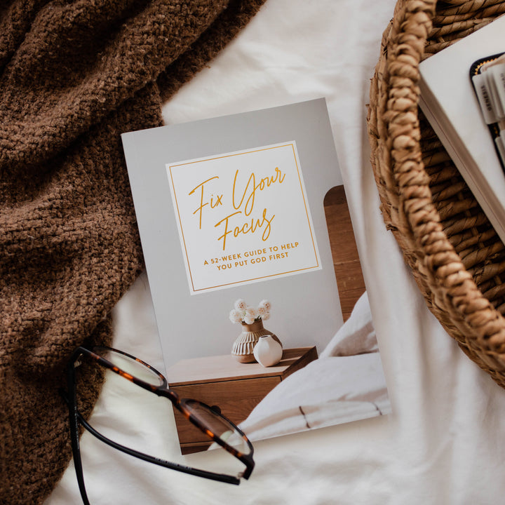 Book titled 'Fix Your Focus' on a surface with glasses and a basket.