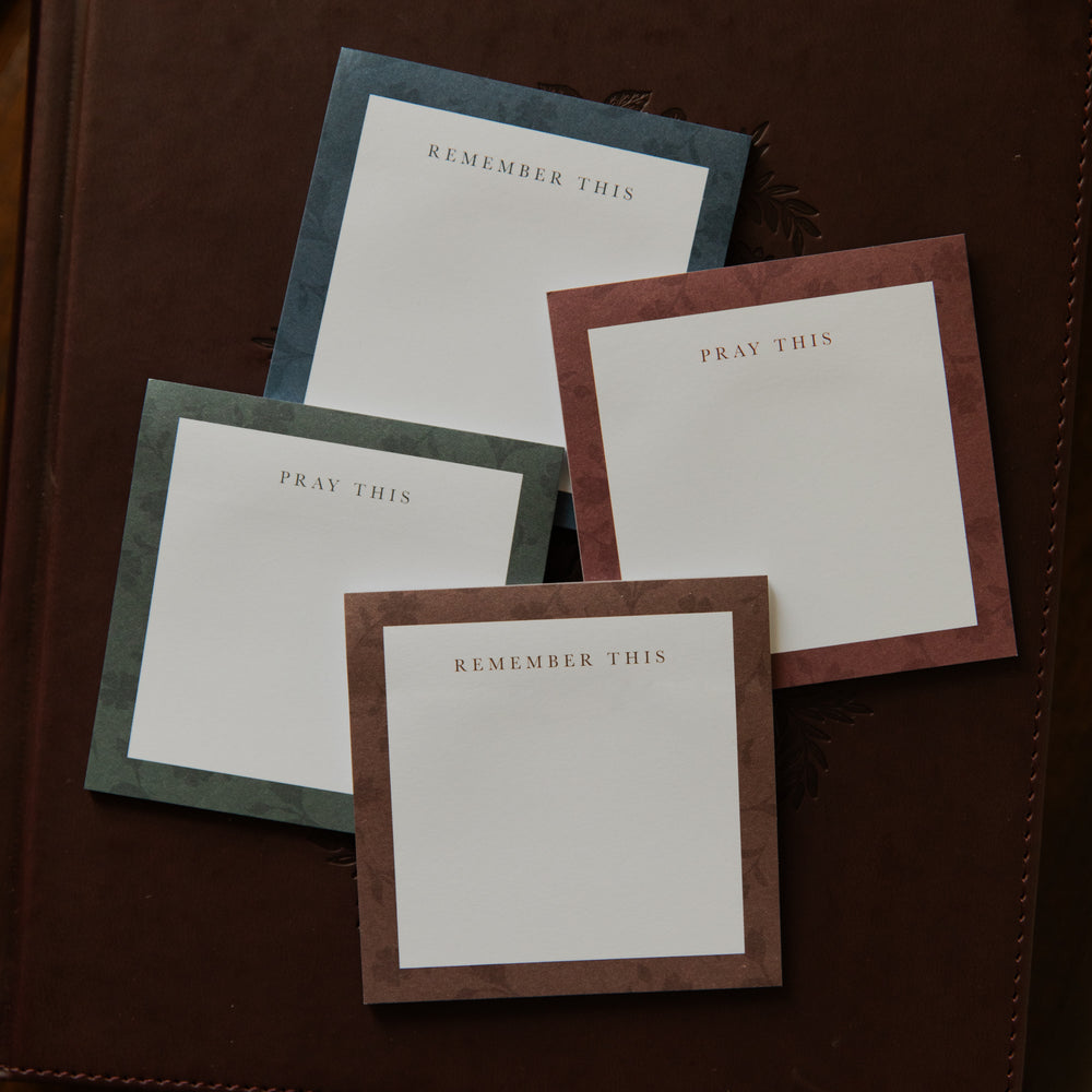 Up close of Four stacks of Floral Border Sticky Notes on a closed bible