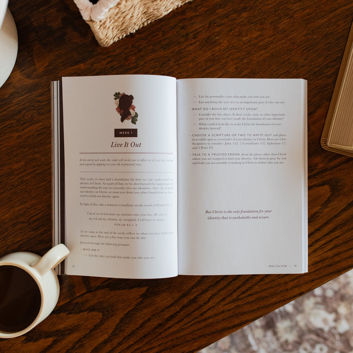 Flourishing in Motherhood Book opened to the week 1 live it out page on a wooden table near a coffee cup