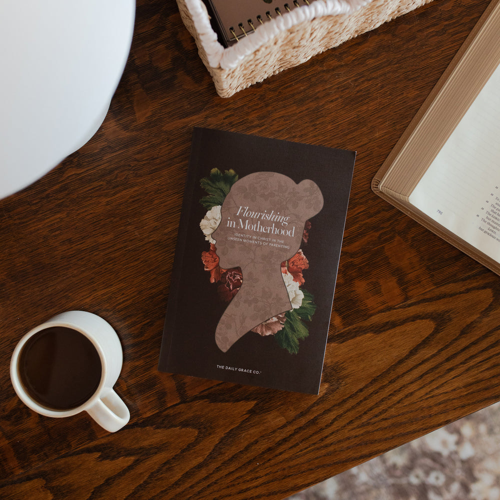 Flourishing in Motherhood Book cover on a wooden table near a coffee cup