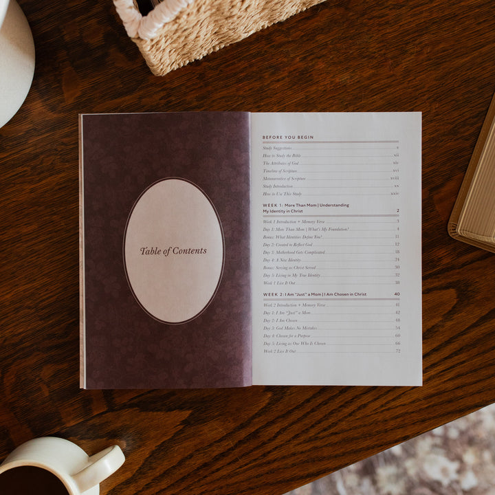 Flourishing in Motherhood Book opened to the table of contents page on a wooden table near a coffee cup