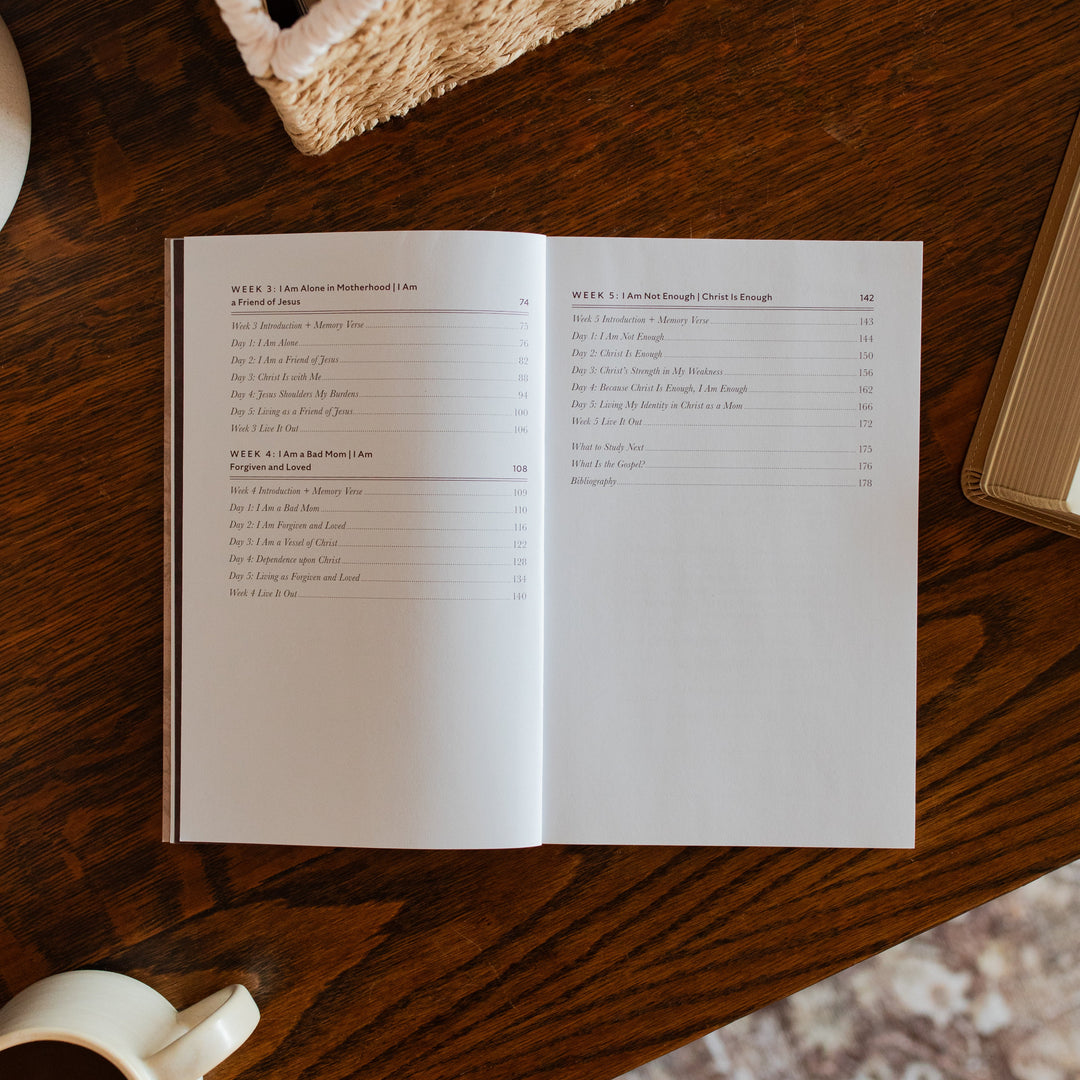 Flourishing in Motherhood Book opened to the end of table of contents page on a wooden table near a coffee cup