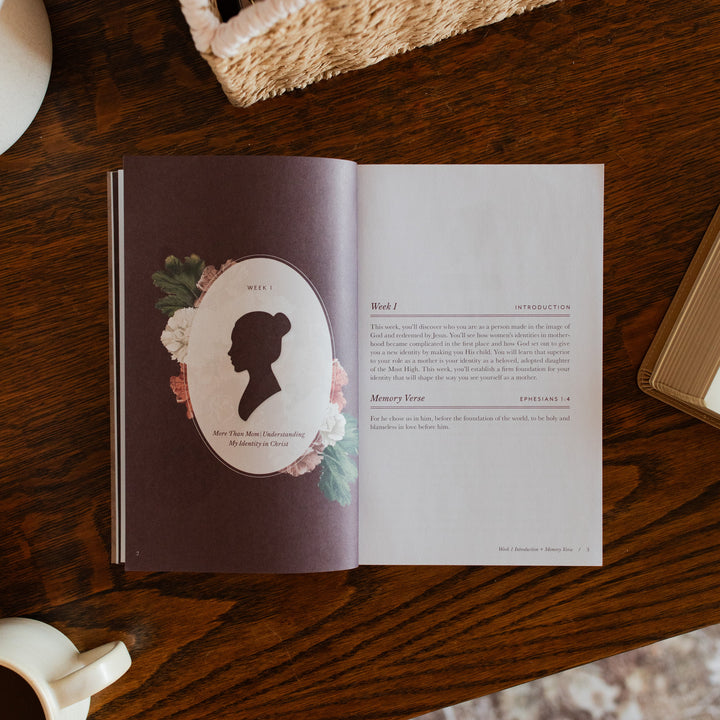 Flourishing in Motherhood Book opened to week 1 introduction page on a wooden table near a coffee cup