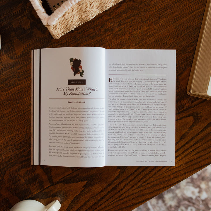 Flourishing in Motherhood Book opened to the week 1 reading page on a wooden table