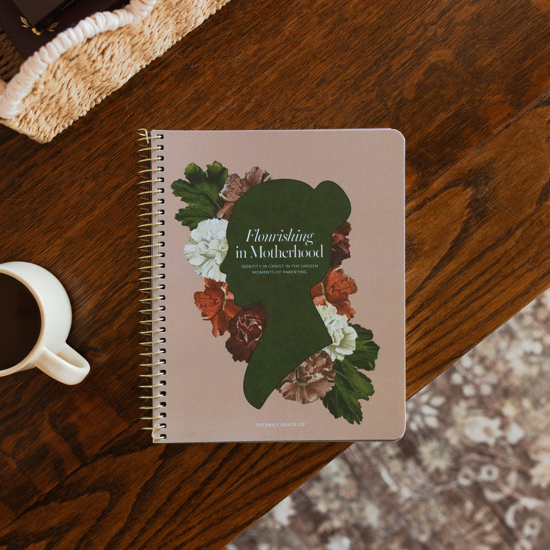 Flourishing in Motherhood spiral study cover on a wooden table near a coffee cup