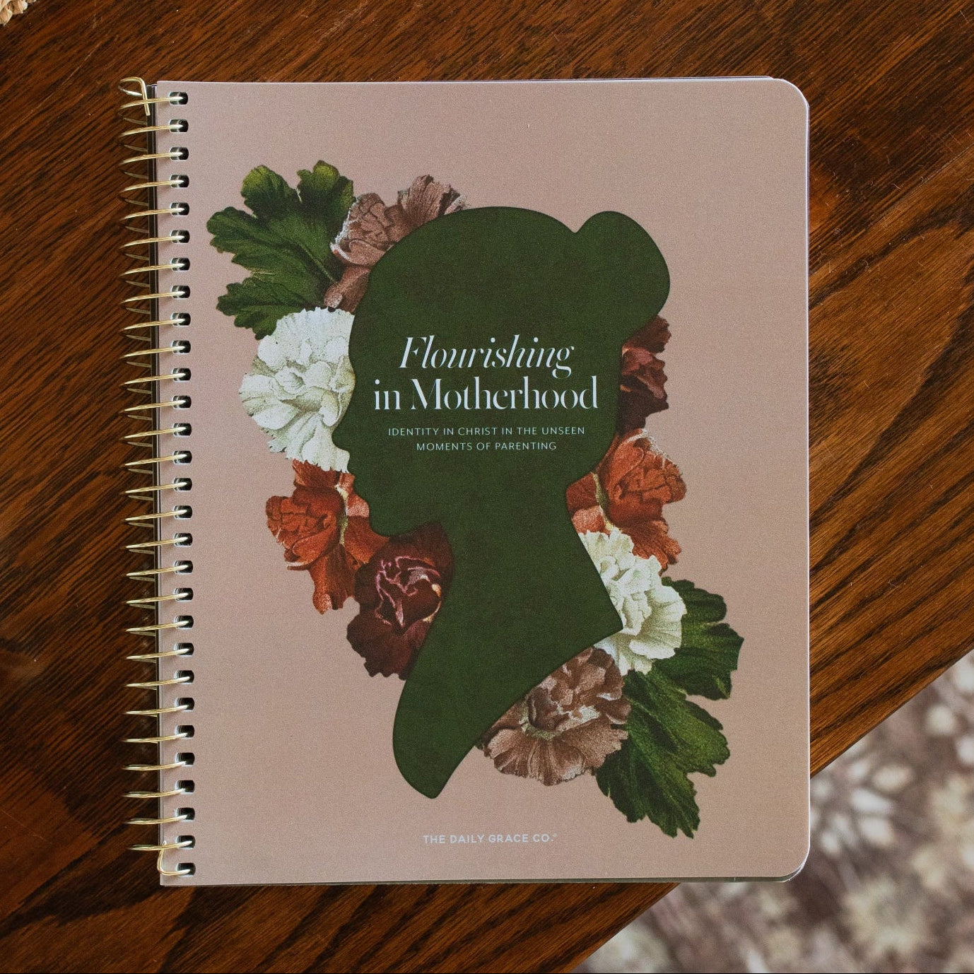 Flourishing in Motherhood spiral study cover on a wooden table near a coffee cup
