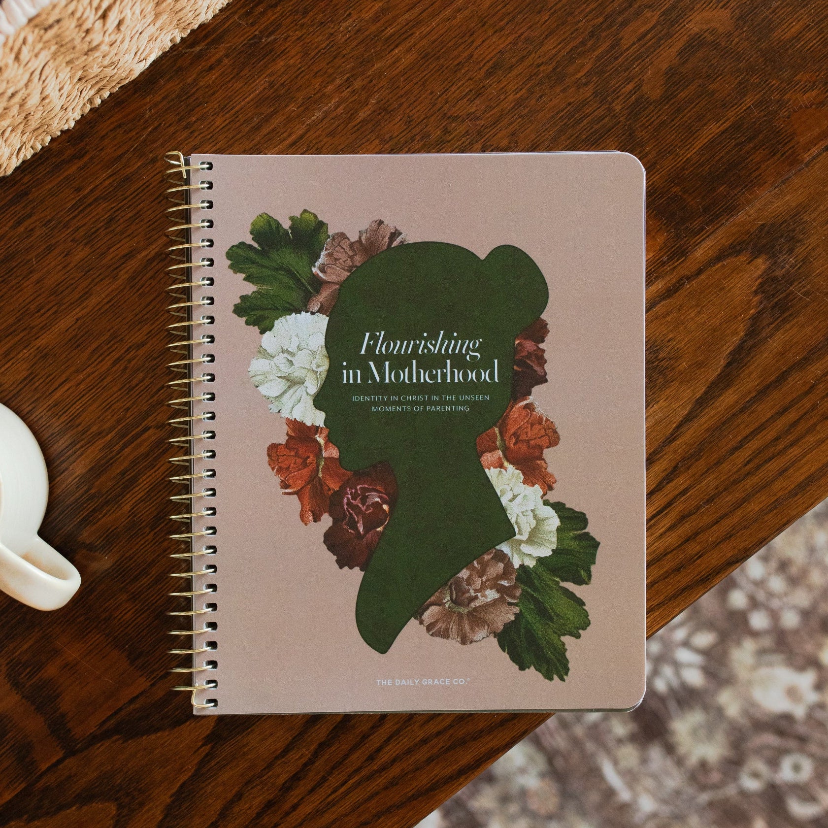 Flourishing in Motherhood spiral study cover on a wooden table near a coffee cup