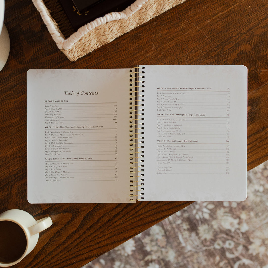 Flourishing in Motherhood spiral study opened to the table of contents page on a wooden table near a coffee cup