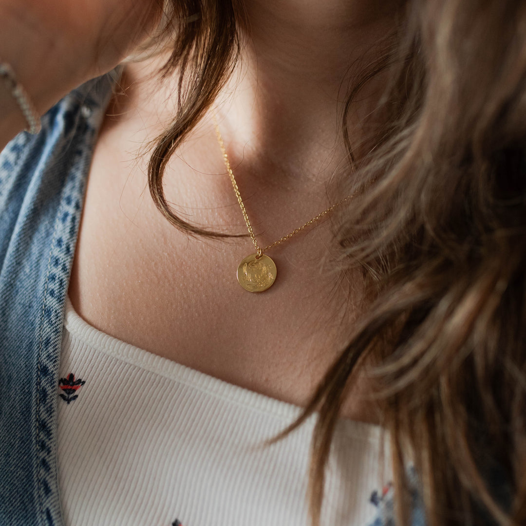 round gold tone necklace on woman