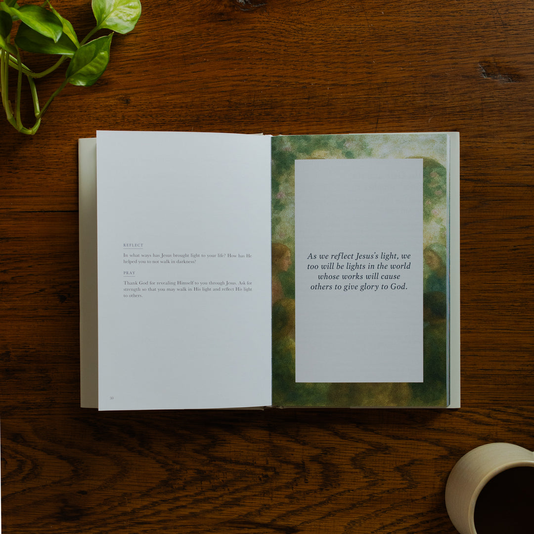 Forty Sayings of Jesus hardcover opened to a reflection and prayer page near a coffee cup on a wooden table