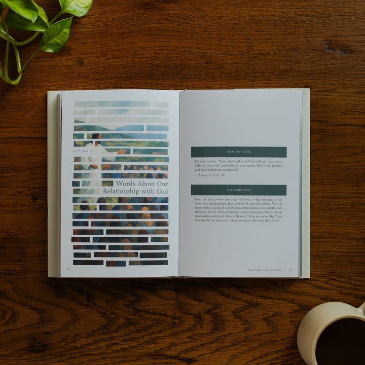 Forty Sayings of Jesus hardcover opened to the Words about Our Relationship with God page near a coffee cup on a wooden table