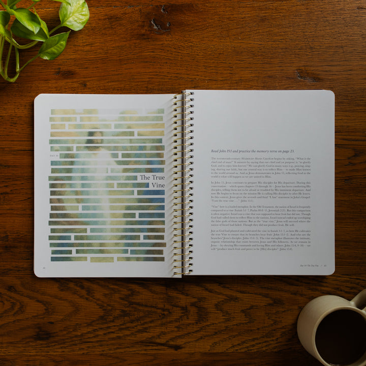 Forty Sayings of Jesus spiral opened to the True Vine page near a coffee cup on a wooden table