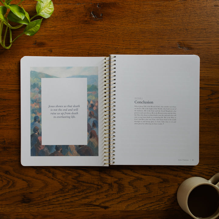 Forty Sayings of Jesus spiral opened to the Conclusions page for section 2 near a coffee cup on a wooden table