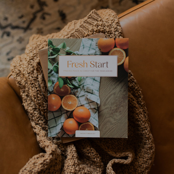 The Fresh Start Bible study on a woven blanket on a brown leather couch
