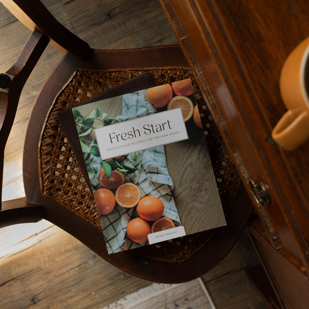 Fresh Start Bible study cover on a wooden woven chair next to a wooden table