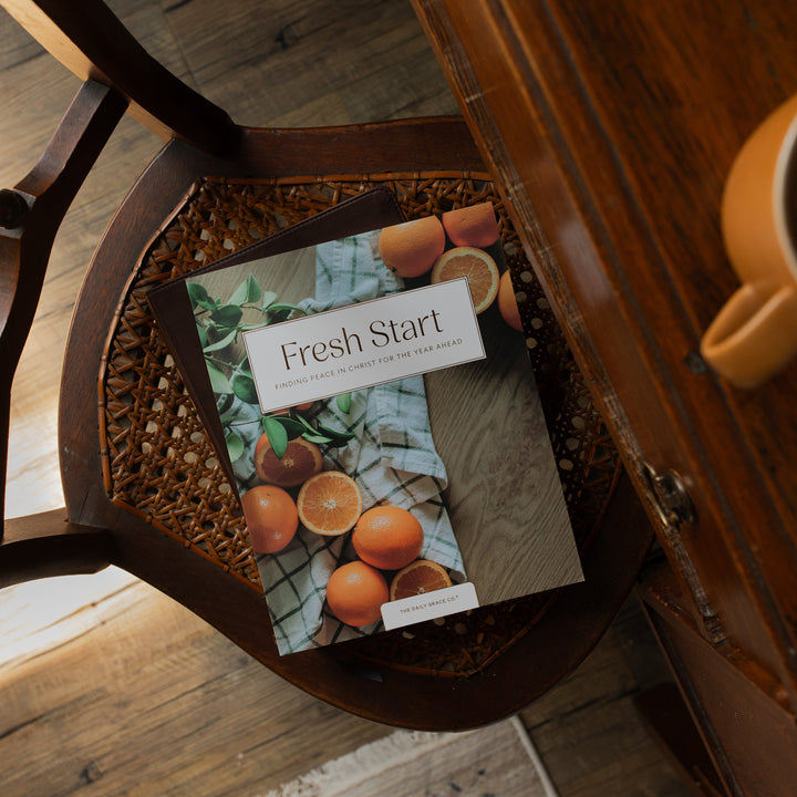 Fresh Start Bible study cover on a wooden woven chair next to a wooden table