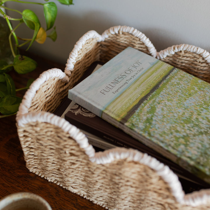 Up close of The Fullness of Joy cover on a stack of other daily grace books in a woven basket