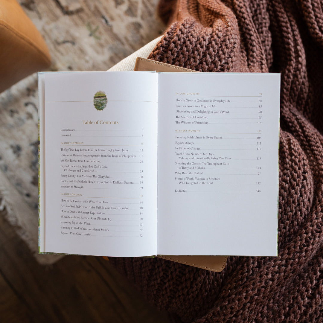 The Fullness of Joy opened to the table of contents page on a closed bible on a knitted blanket