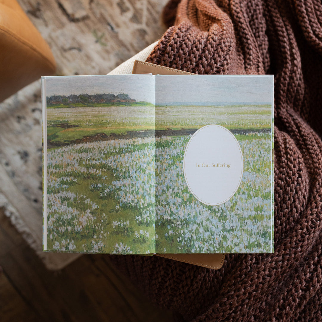 The Fullness of Joy opened to the In Our Suffering Image page on a closed bible on a knitted blanket