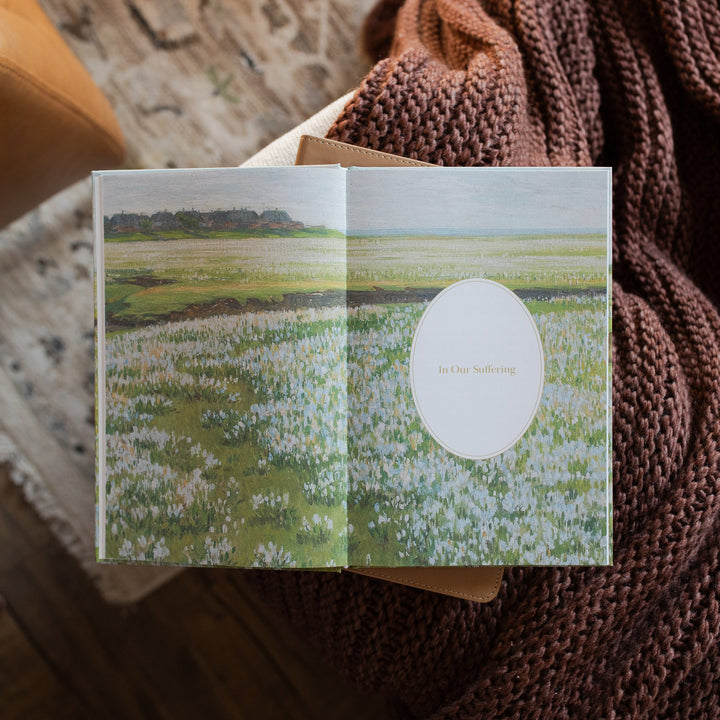 The Fullness of Joy opened to the In Our Suffering Image page on a closed bible on a knitted blanket