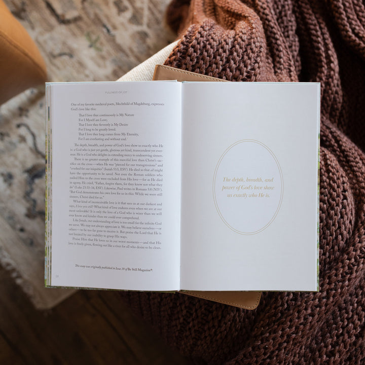 The Fullness of Joy opened to a devotional page on a closed bible on a knitted blanket